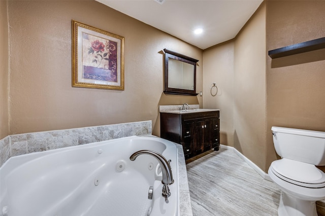 bathroom with vanity, hardwood / wood-style flooring, toilet, and a bathtub