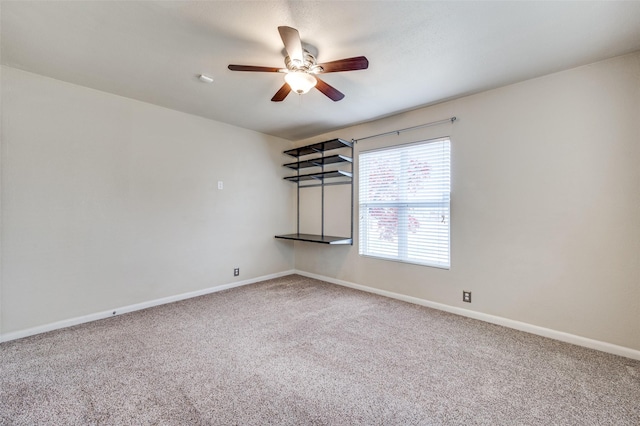 spare room with ceiling fan and carpet