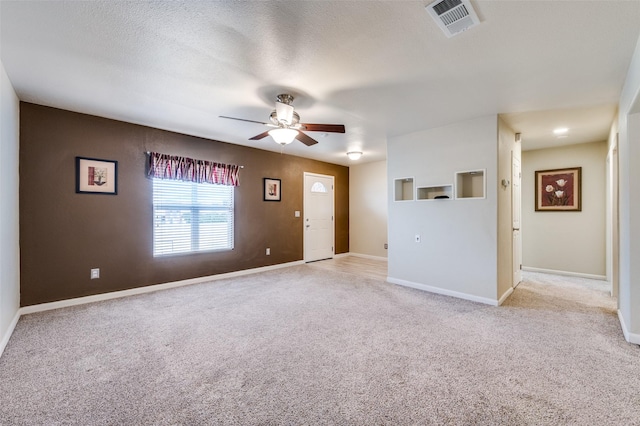 unfurnished living room featuring a textured ceiling, light colored carpet, and ceiling fan