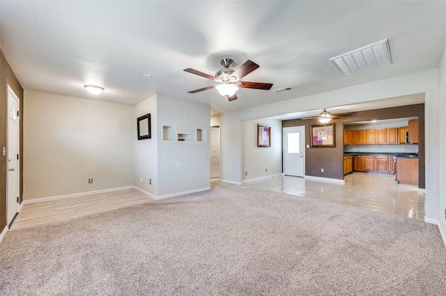 unfurnished living room featuring ceiling fan and light carpet