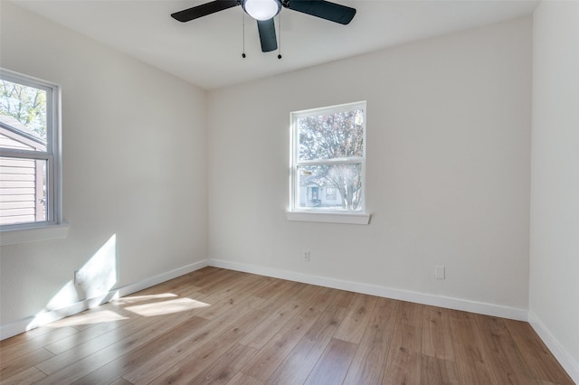 spare room featuring a wealth of natural light, ceiling fan, and light hardwood / wood-style floors