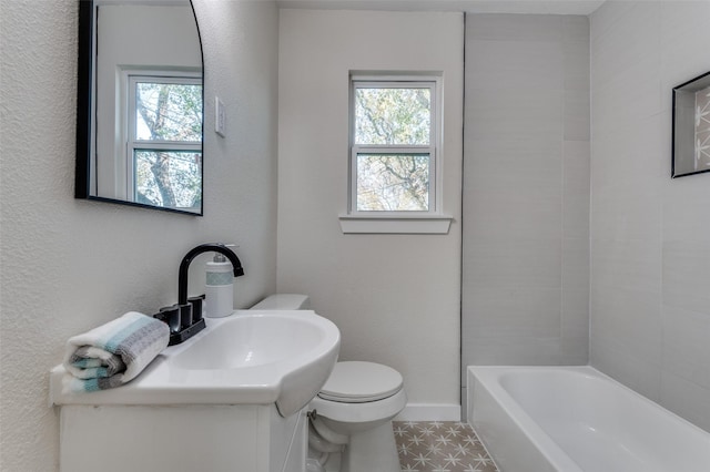 bathroom with toilet, a bath, and a wealth of natural light