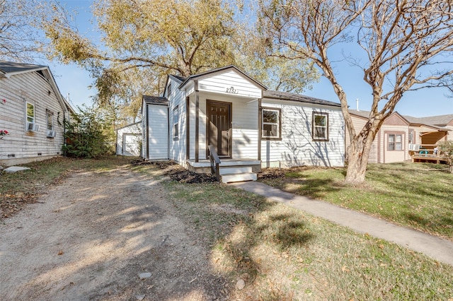 view of front facade with a garage, an outbuilding, and a front yard