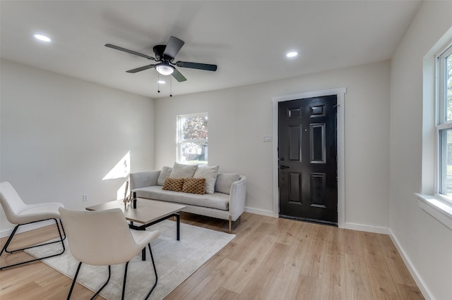 living room with light wood-type flooring and ceiling fan