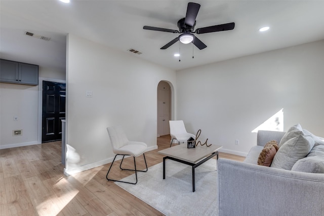 living room with light hardwood / wood-style flooring and ceiling fan