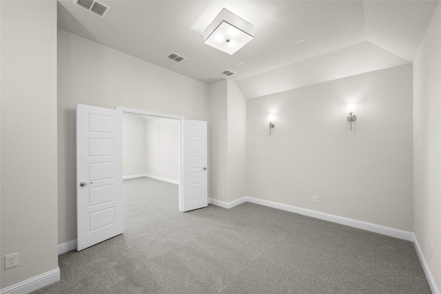 interior space with carpet floors, lofted ceiling, and visible vents