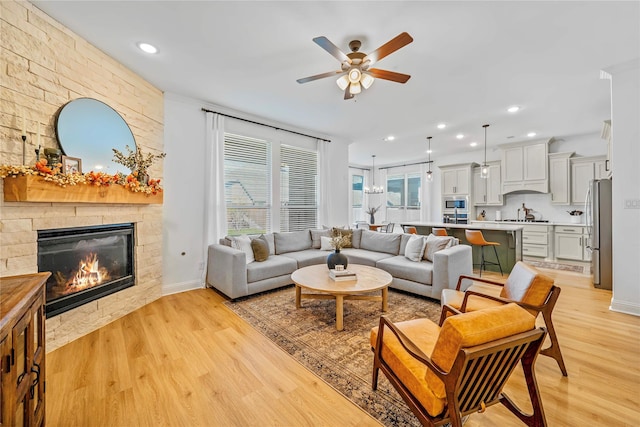 living room with light wood-style flooring, recessed lighting, and a fireplace