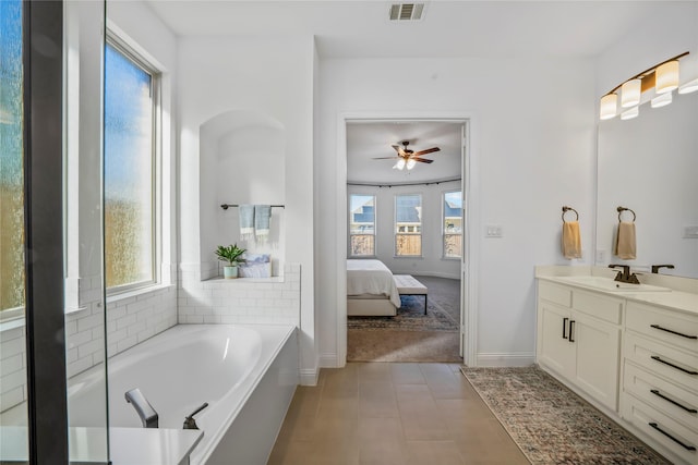 ensuite bathroom with visible vents, a tub, baseboards, vanity, and ensuite bath