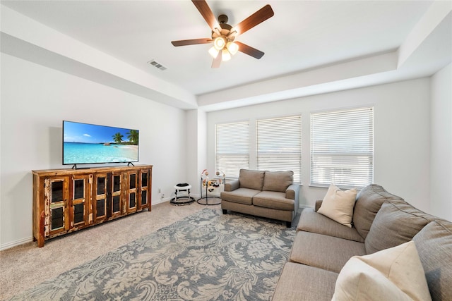 carpeted living area featuring a ceiling fan, baseboards, and visible vents