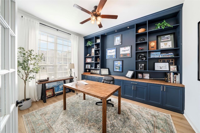 office area with light hardwood / wood-style floors, built in features, ceiling fan, and ornamental molding