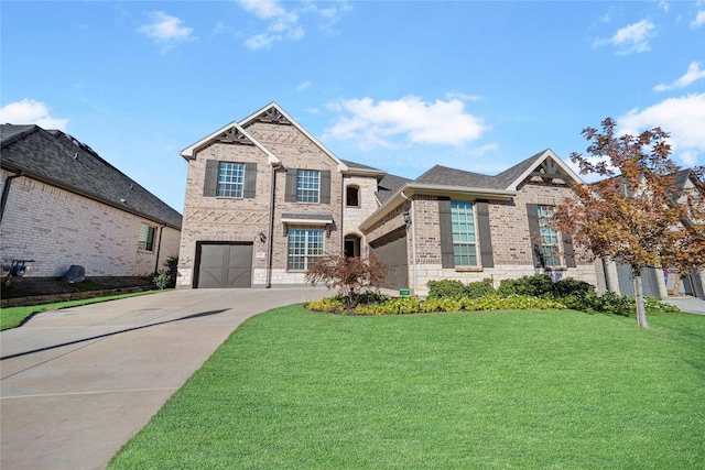 view of front of house featuring brick siding, an attached garage, concrete driveway, and a front lawn