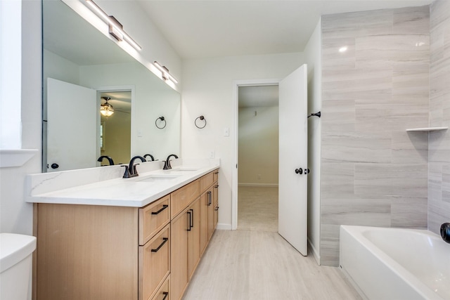 bathroom with hardwood / wood-style floors, vanity, toilet, and ceiling fan