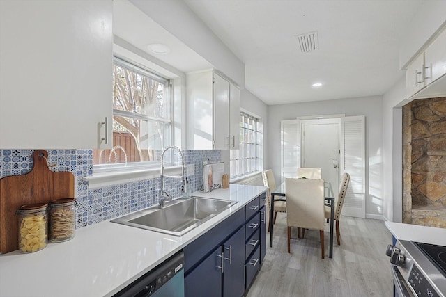 kitchen featuring white cabinets, blue cabinets, plenty of natural light, and sink