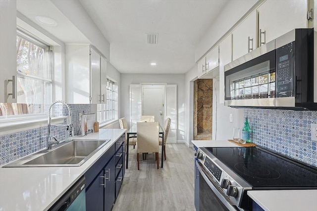 kitchen featuring white cabinetry, sink, light hardwood / wood-style flooring, blue cabinets, and appliances with stainless steel finishes