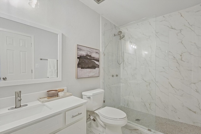 bathroom featuring vanity, toilet, and tiled shower