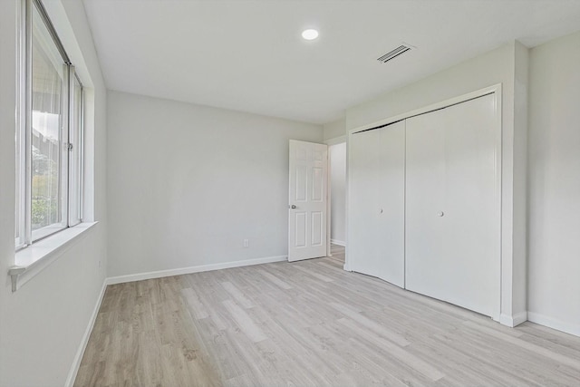 unfurnished bedroom featuring a closet and light hardwood / wood-style flooring