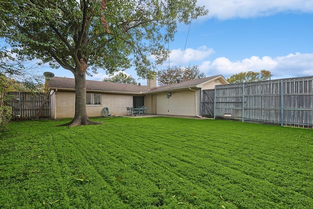 rear view of property with a lawn and a patio