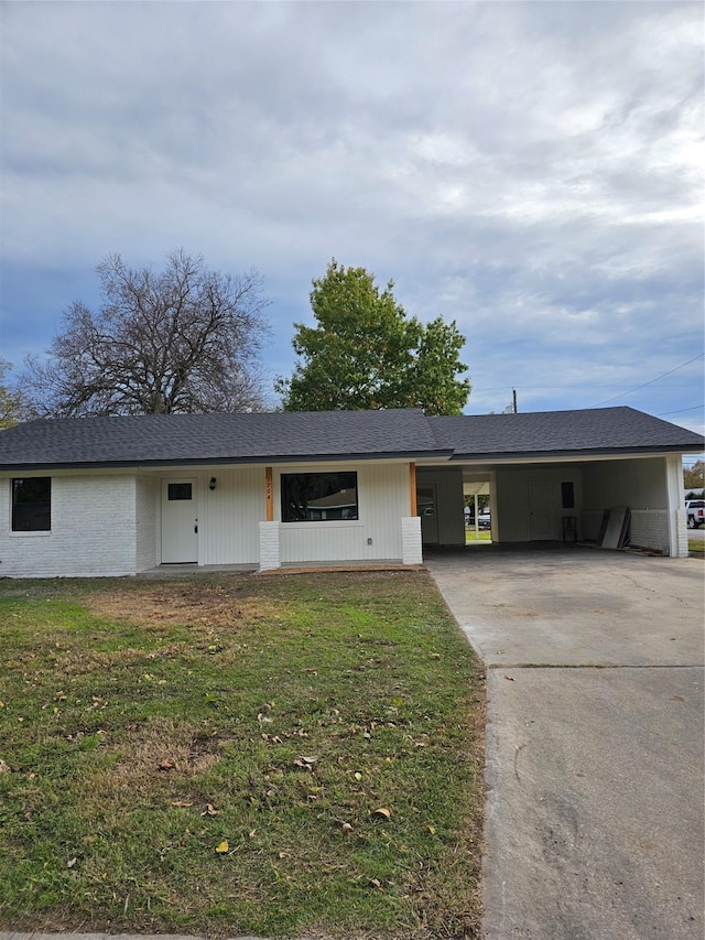 ranch-style house featuring a carport and a front lawn