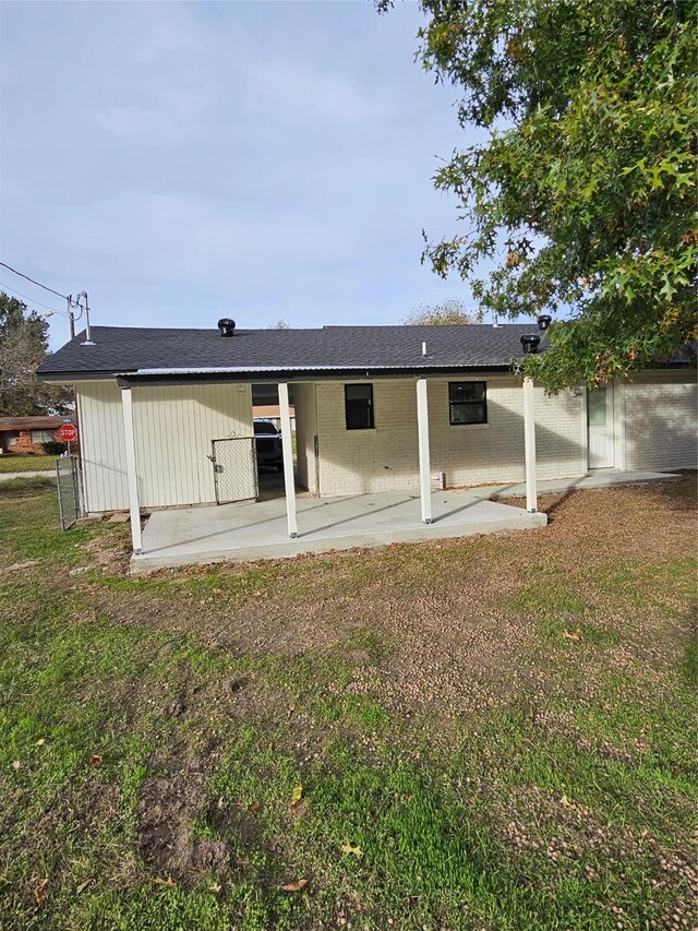 rear view of house with a lawn and a patio area