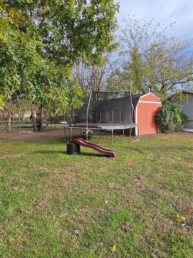 view of yard with a trampoline and a storage shed