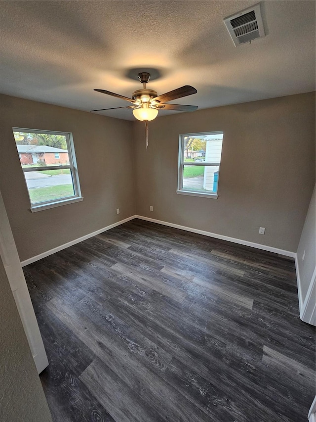 unfurnished room featuring ceiling fan, dark wood-type flooring, and a textured ceiling