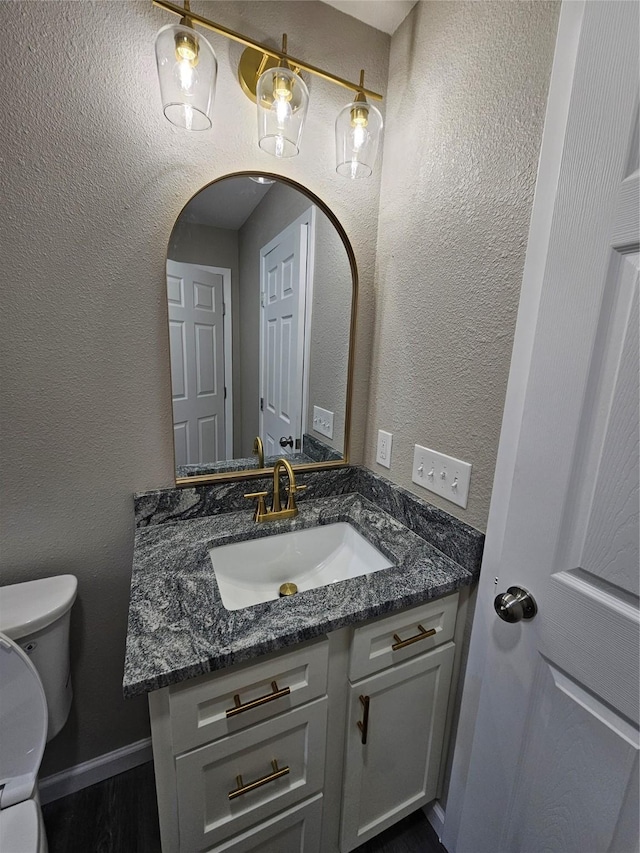 bathroom with vanity, hardwood / wood-style floors, and toilet