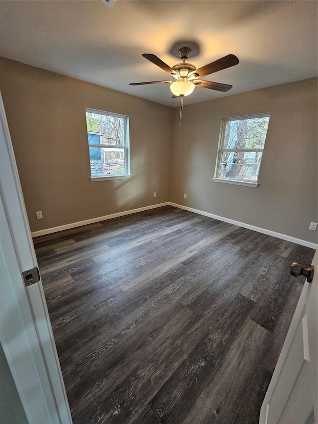 empty room with ceiling fan and dark hardwood / wood-style flooring