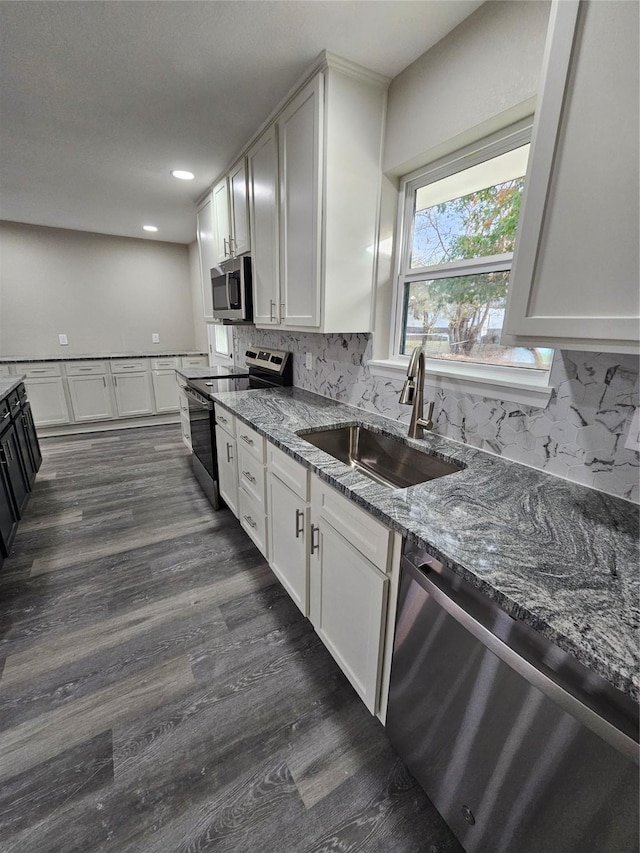 kitchen with stainless steel appliances, sink, white cabinets, and stone counters