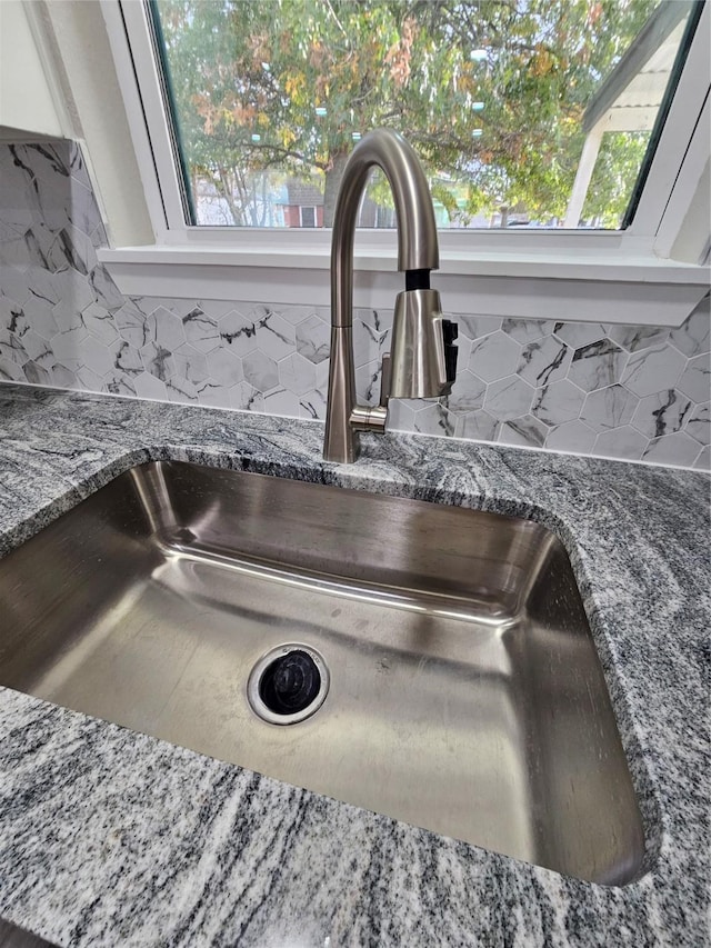 interior details featuring stone counters, tasteful backsplash, and sink