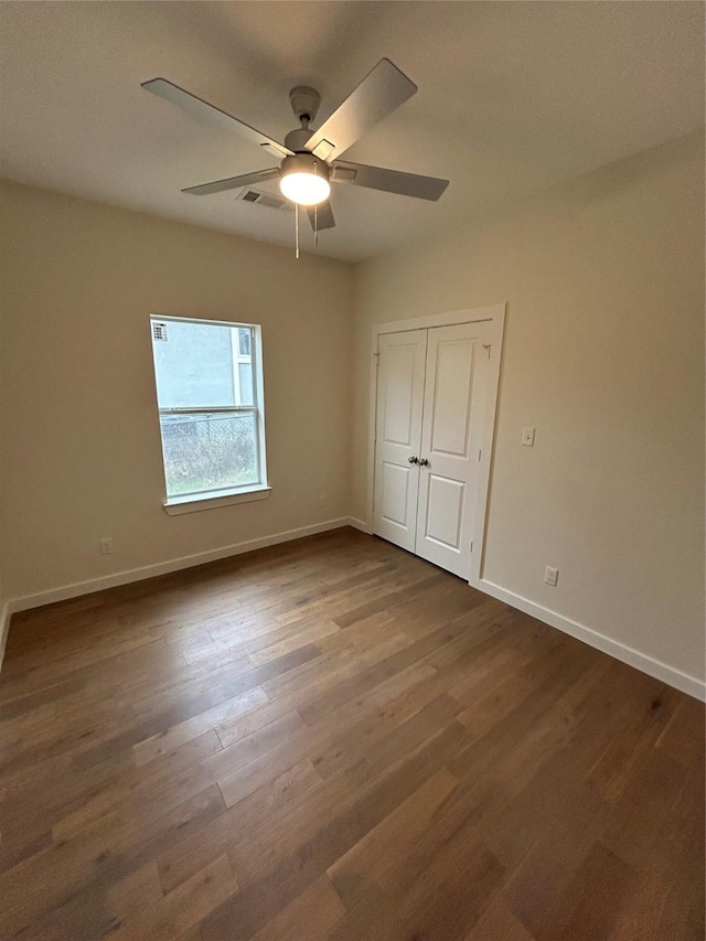 spare room featuring ceiling fan and dark hardwood / wood-style floors