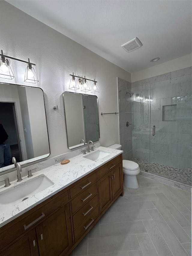 bathroom featuring vanity, an enclosed shower, and toilet