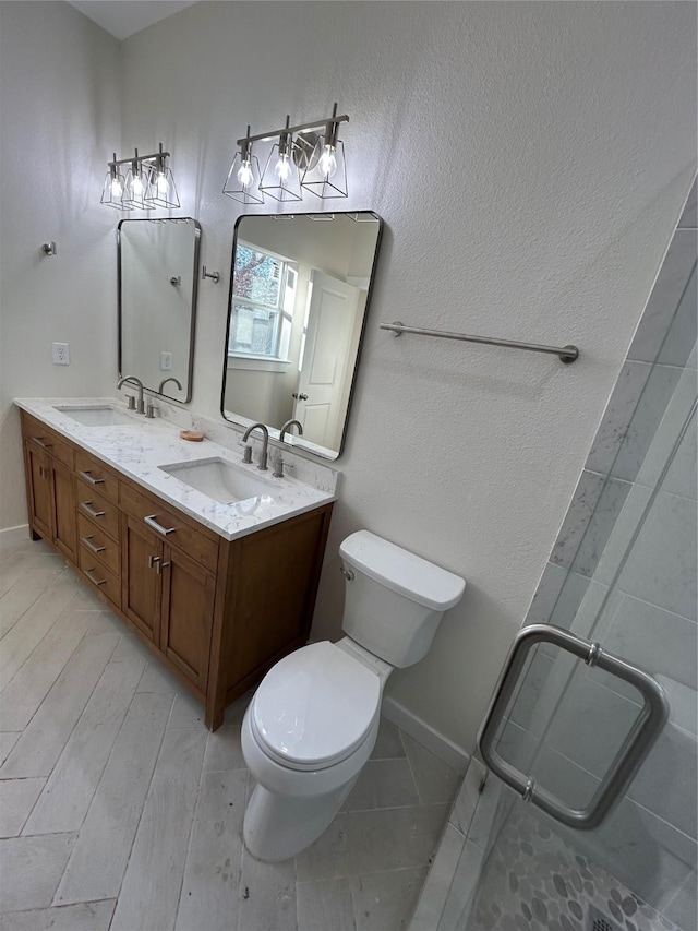 bathroom with vanity, wood-type flooring, a shower with shower door, and toilet