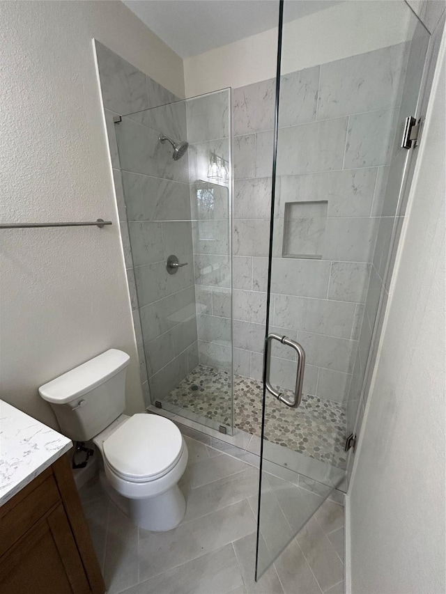 bathroom featuring vanity, an enclosed shower, tile patterned floors, and toilet