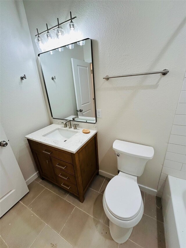 bathroom with vanity, tile patterned floors, a bathtub, and toilet