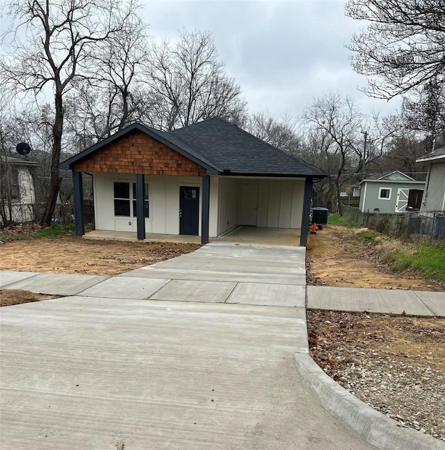 view of front facade with central AC, a carport, and covered porch