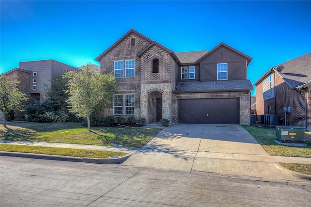 view of front of home with a garage, a front yard, and central air condition unit