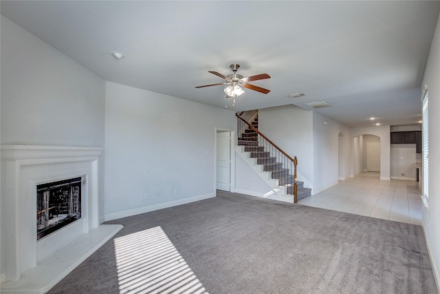 unfurnished living room with light colored carpet and ceiling fan