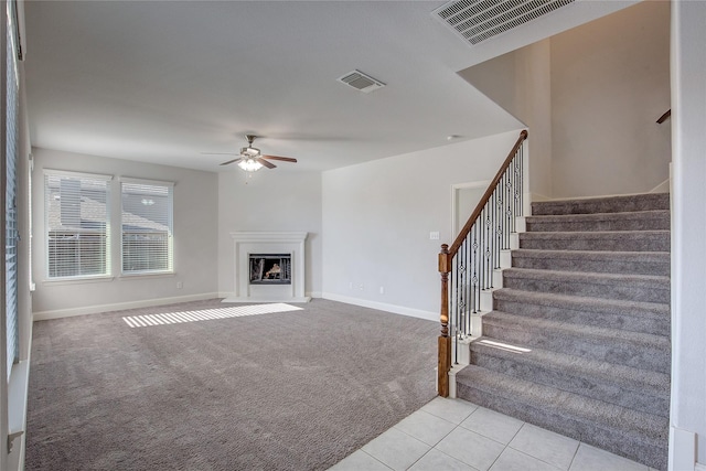 unfurnished living room featuring light colored carpet and ceiling fan