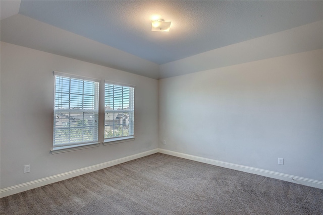 carpeted empty room with a textured ceiling