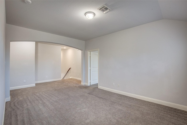 carpeted empty room featuring lofted ceiling