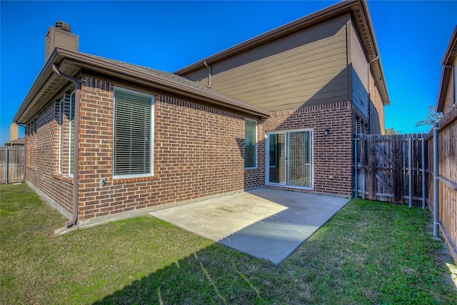 back of house featuring a lawn and a patio area