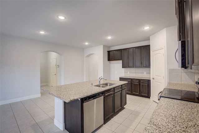 kitchen featuring light tile patterned flooring, appliances with stainless steel finishes, sink, and an island with sink