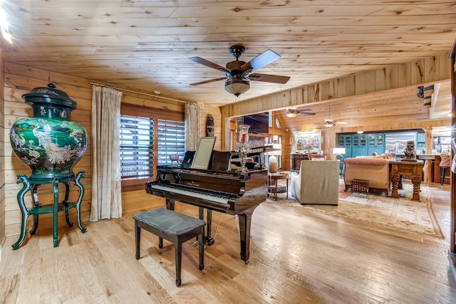 misc room with light hardwood / wood-style flooring, plenty of natural light, and wooden walls