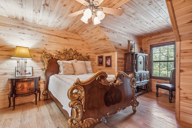 bedroom featuring ceiling fan, light hardwood / wood-style floors, lofted ceiling, and wooden walls