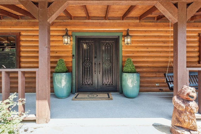 doorway to property with covered porch and french doors