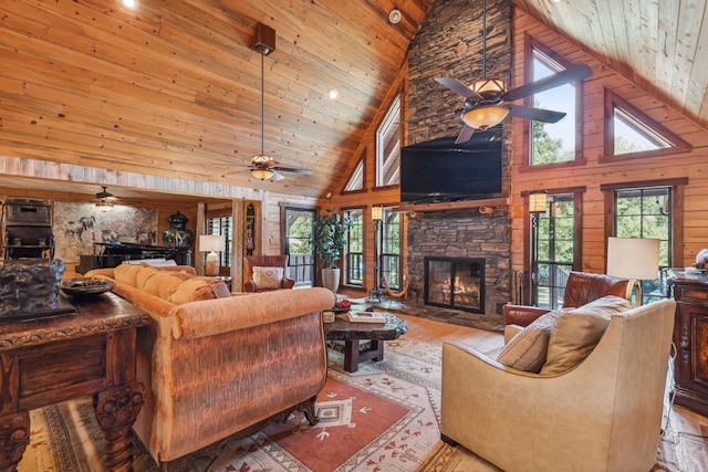 living room with wood walls, wooden ceiling, high vaulted ceiling, a fireplace, and light hardwood / wood-style floors