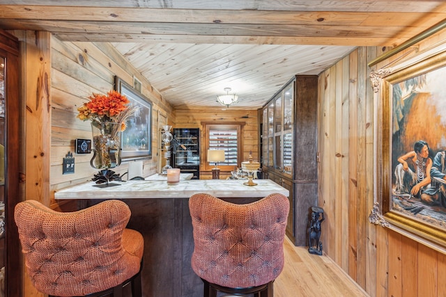 bar featuring wood walls, light hardwood / wood-style floors, wood ceiling, and beamed ceiling