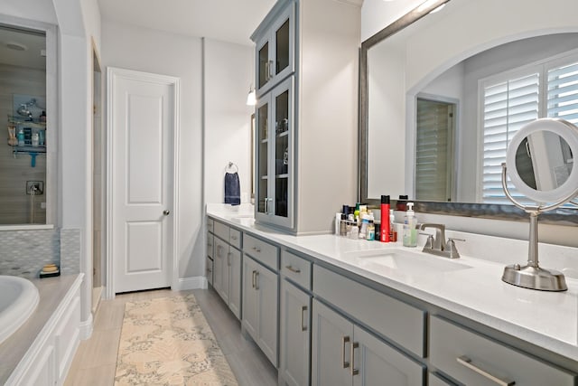 bathroom featuring vanity, tiled bath, and tile patterned floors