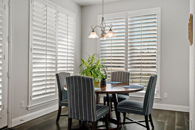 dining room featuring dark wood-type flooring and an inviting chandelier