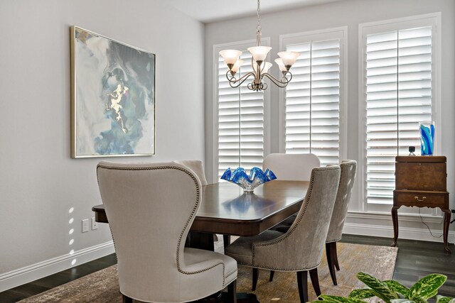 dining space with a notable chandelier and dark hardwood / wood-style flooring